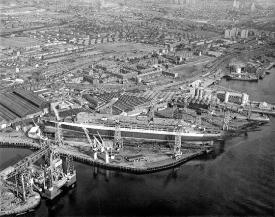 Aerial view of the Cunard liner RMS Queen Elizabeth 2 under construction at the shipyard of John Brown and Company, Clydebank. 
Image courtesy of National Records of Scotland.